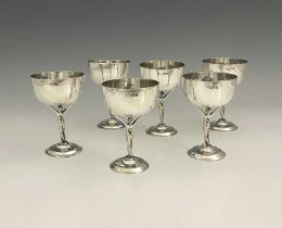 A set of six Edwardian silver wine cups, each with cast figural stem of a maiden in a flowing gown