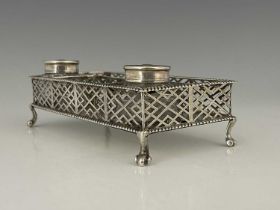 A George II silver two-bottle inkstand or desk stand, of rectangular form, the raised reticulated