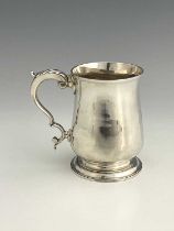 A George III silver pint mug, of baluster form, with double C scroll handle and acanthus leaf