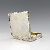 An Elizabeth II silver box, of squat cuboid form, the engine-turned body surmounted with a cast