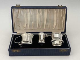 A George V silver three-piece condiment set, comprising mustard pot, of drum form, with hinged cover