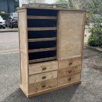 A haberdashery style pine and board linen press/storage Unit, fitted two sliding doors revealing