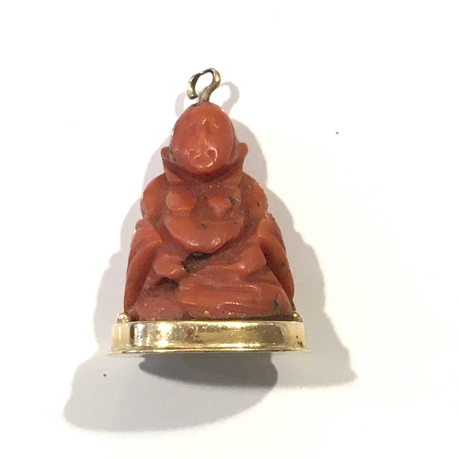 A gold mounted coral Buddha pendant