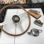 A Jaguar E-Type steering wheel, a Jaguar left nearside wheel nut, two mascots and a desk blotter (