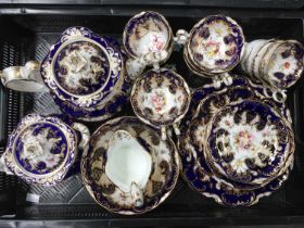 An English porcelain part tea service, possibly Coalport, painted with floral sprays within gilded