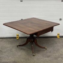 A mahogany Pembroke table, on four downward sweeping supports terminating in brass caps and