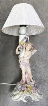 A Von Schierholz porcelain lampbase, circa 1930, modelled as a cherub holding a floral encrusted