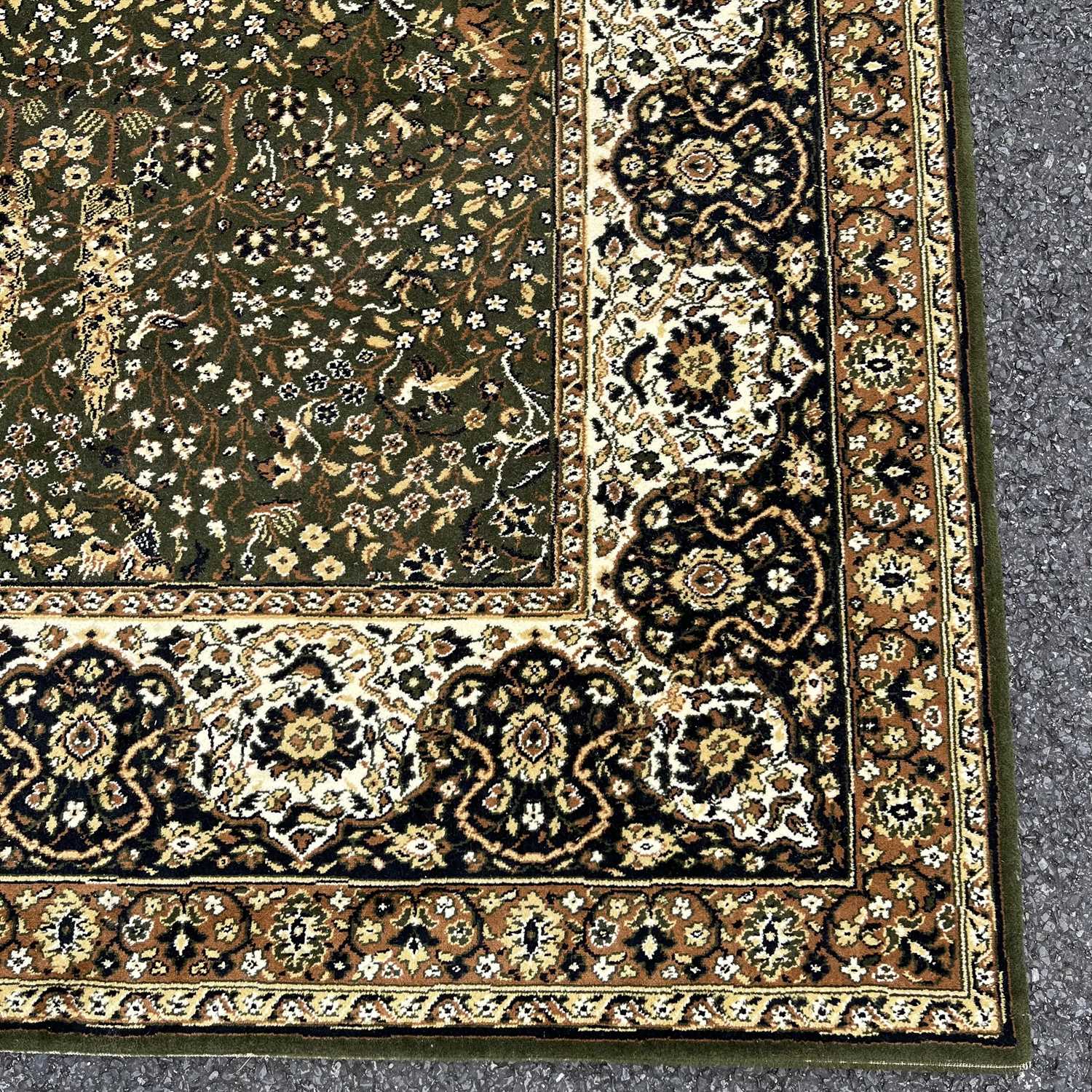 A large rug, muted green field with cream medallion and border designs, covered with floral and - Image 2 of 6