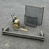 A brass coal scuttle, fire companion set, a brass fire kerb with reticulated scroll frieze and a