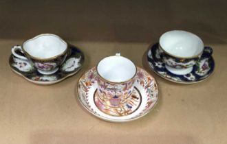 A Spode coffee can and saucer alongside 2 decorative cups and suacers with insects and birds