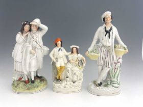 Three Staffordshire figure groups , circa 1865, one modelled as a standing male fruitseller in white