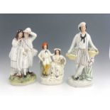 Three Staffordshire figure groups , circa 1865, one modelled as a standing male fruitseller in white