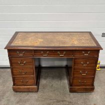 A writing desk, with a brown tooled leather writing surface, with gilt detail, fitted one long