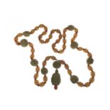 A string of carved composite Hediao style beads, strung with amber type cylindrical beads and carved