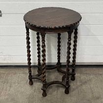 An occasional table, scalloped edge, with barley twist supports, united by a star shaped stretcher