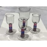 Four studio glass wine glasses, three port glasses and a goblet, multi-coloured stems,