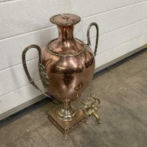 A copper samovar, ovoid form, with twin loop handles, on square reticulated base, with brass tap