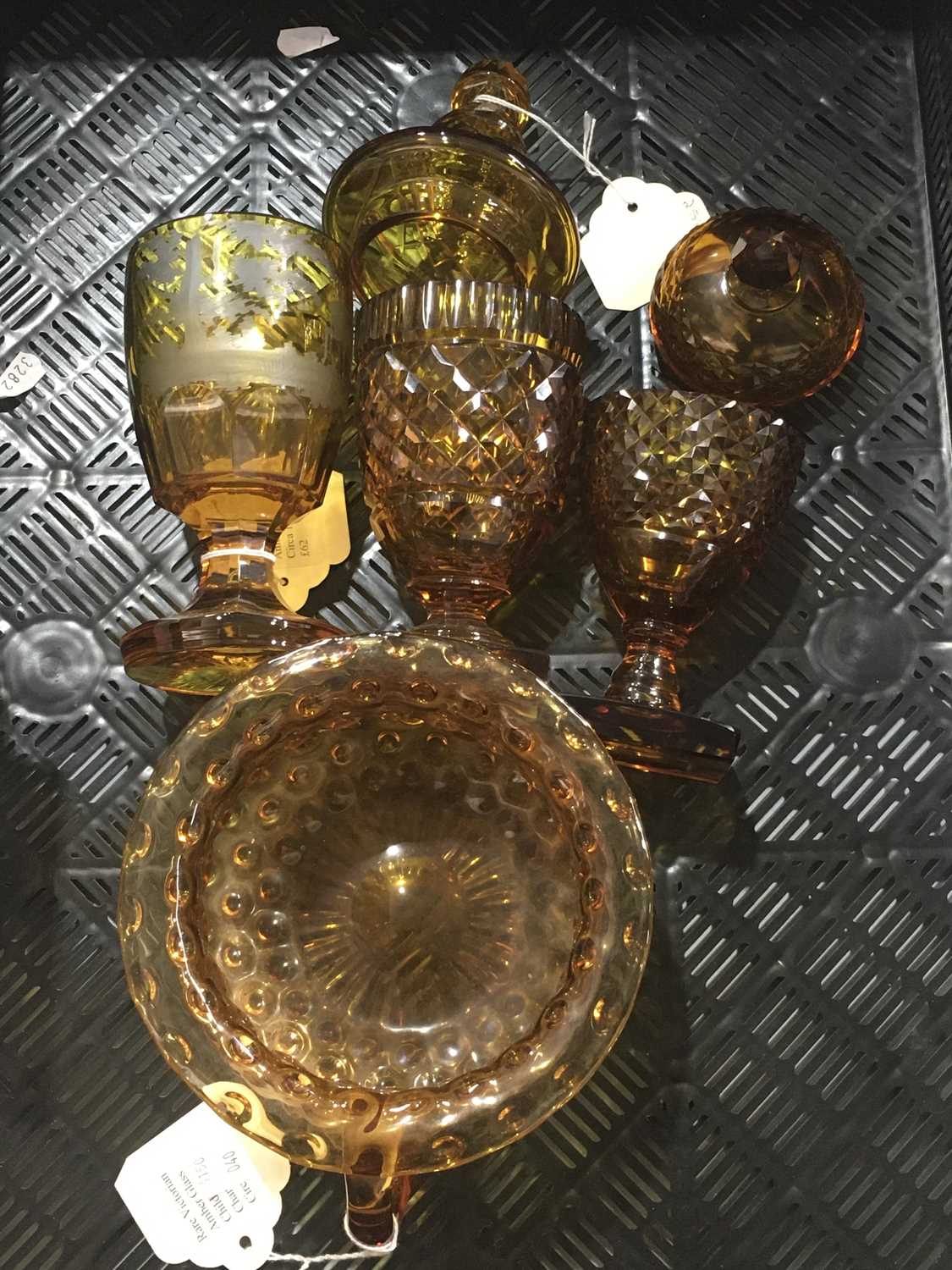 A collection of Bohemian amber glassware, including two sweetmeat jars and covers, a goblet with