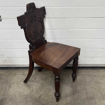 A 19th Century mahogany hall chair, heraldic back, with turned and sabre supports