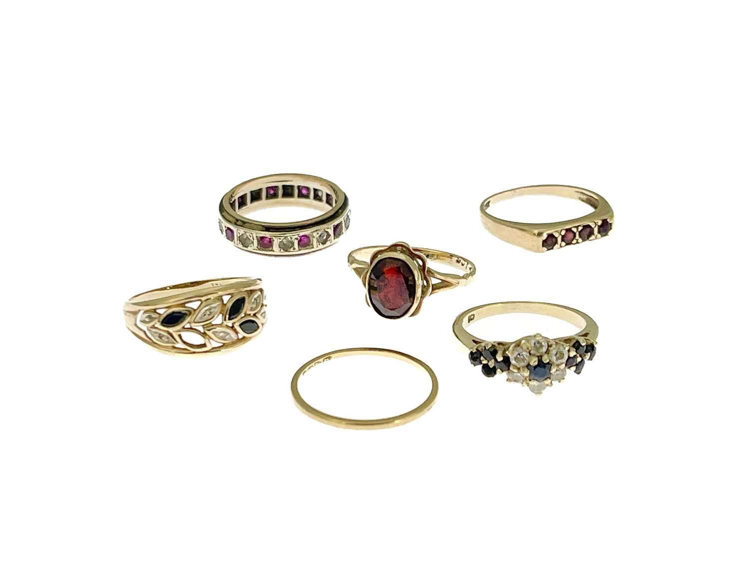 Six gold and gem set rings, including a diamond and sapphire dress ring, an eternity ring and fine