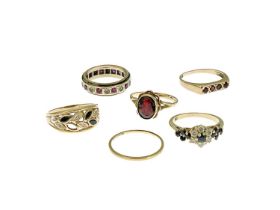 Six gold and gem set rings, including a diamond and sapphire dress ring, an eternity ring and fine