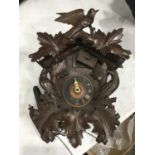 A Black Forest carved wooden cuckoo clock, bird house form with carved bird and foliate pediment,