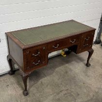 A mahogany kneehole desk, circa 1930, with tooled leather top, fitted five drawers: one long flanked