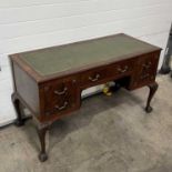 A mahogany kneehole desk, circa 1930, with tooled leather top, fitted five drawers: one long flanked