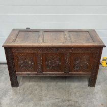 An oak chest, carved floral panels to the front, on block supports W: 125 cm D: 54 cm H: 69