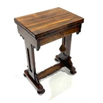 A William IV rosewood swivel-top games table, on trestle style supports and bun feet, W: 76 cm (