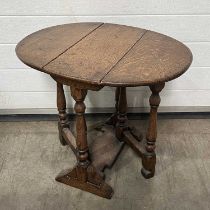 A oak small gate-leg table, turned legs, united by trestle style stretcher W: 61 cm D: 47.5 cm H: