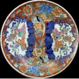 A pair of Japanese plates in an Imari palette with floral decoration, exotic birds and elegantly