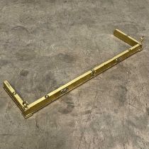 A brass fender W: 132 cm D: 35 cm