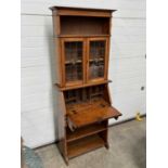 A bureau bookcase, single shelf and glass-front cabinet doors above fall-down slant front