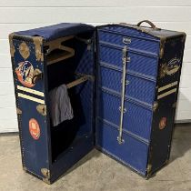 A vintage steamer trunk, decorated with "W.B.D" and various Cunard White Star stickers, fitted