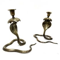 A pair of brass cobra candlesticks, with floral engravings 20 cm tall