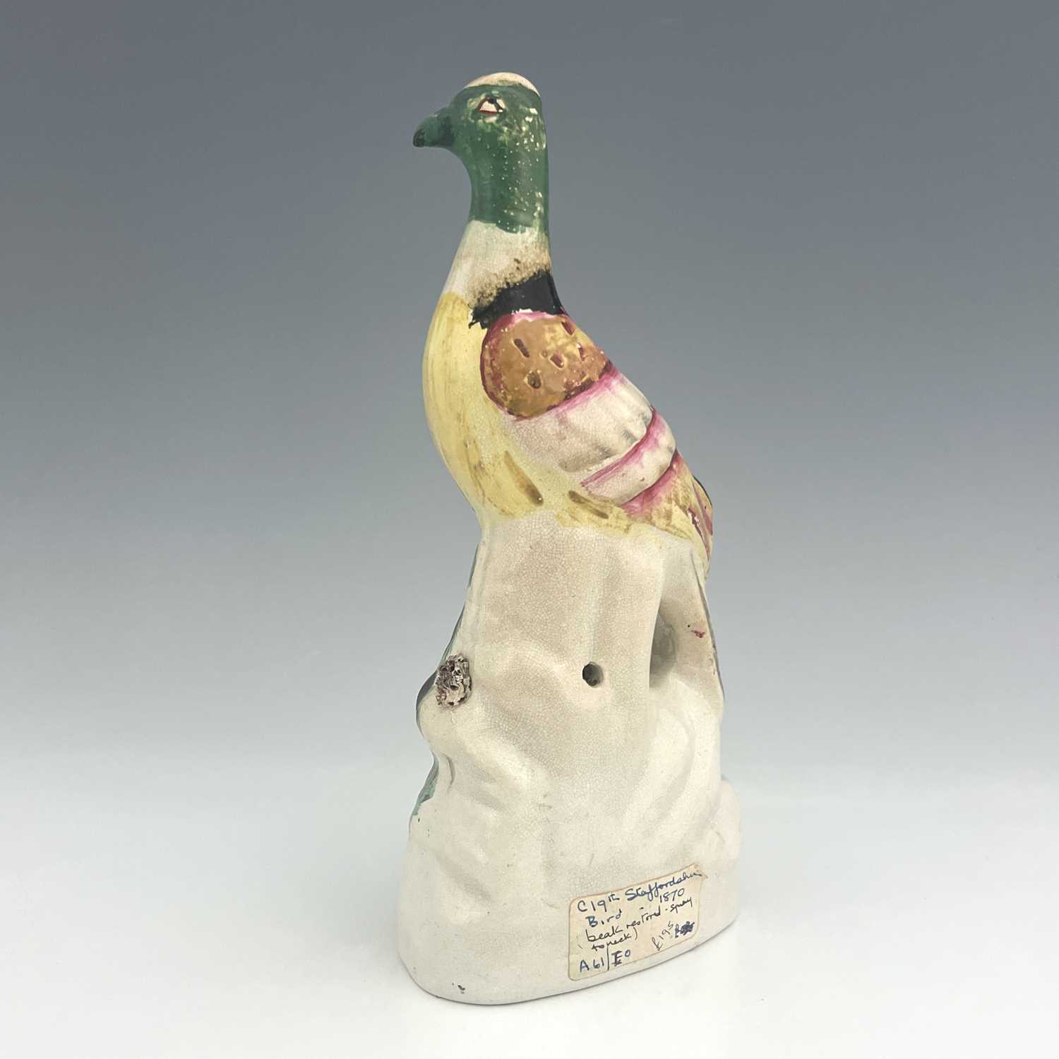 A Staffordshire pottery exotic bird, circa 1850, modelled perched on a green and brown mound, on - Image 2 of 4