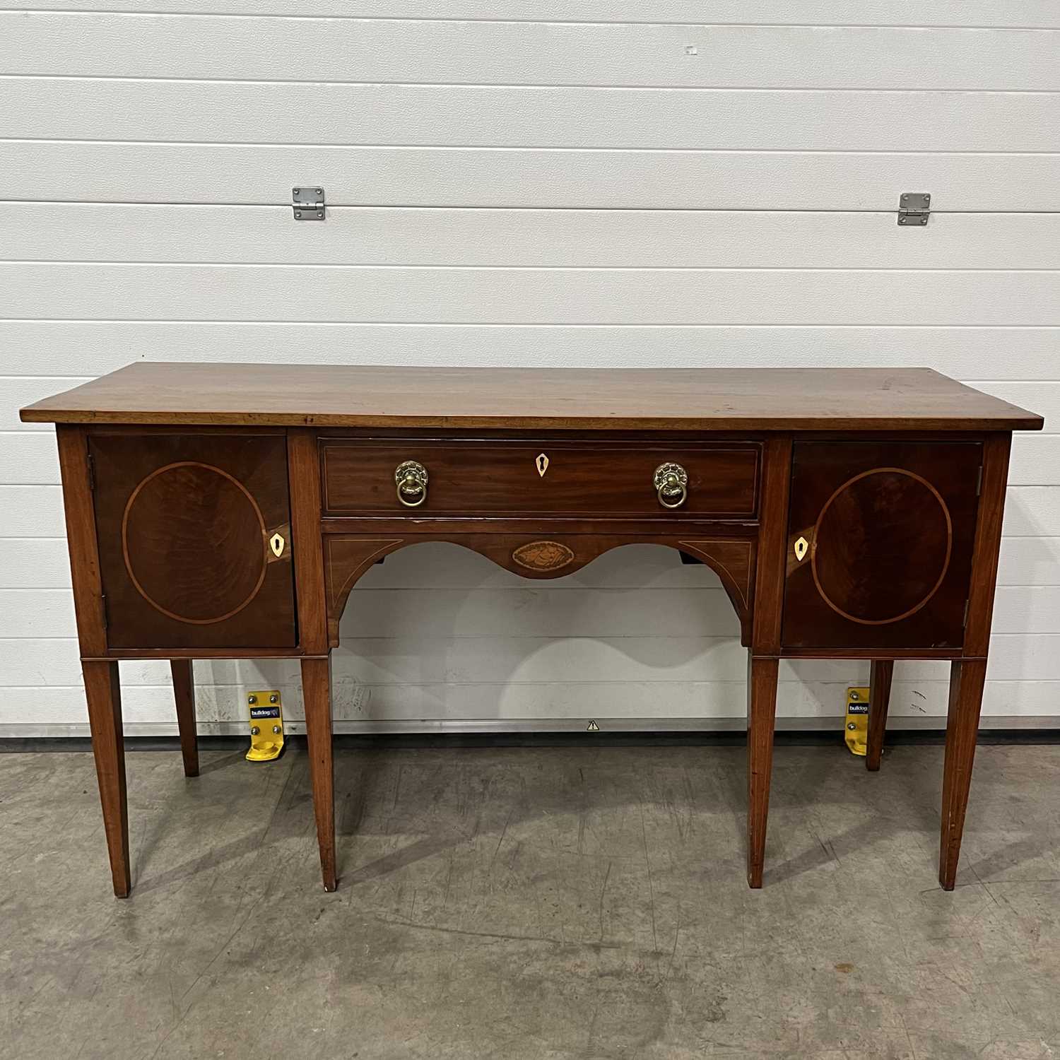 A sideboard, fitted single drawer width ring-pull handles, over serpentine marquetry inlaid front,