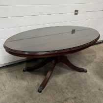 A regency style oval coffee table, with a glass top, on four splayed, reeded supports W: 120 cm D: