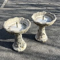 A pair of reconstituted stone fountains/birdbaths, dished baths, on flared base decorated with