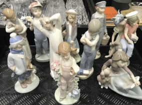 A collection of ten Lladro figures, including A Lesson Shared, Caribbean Kiss, Dutch Boy with Milk