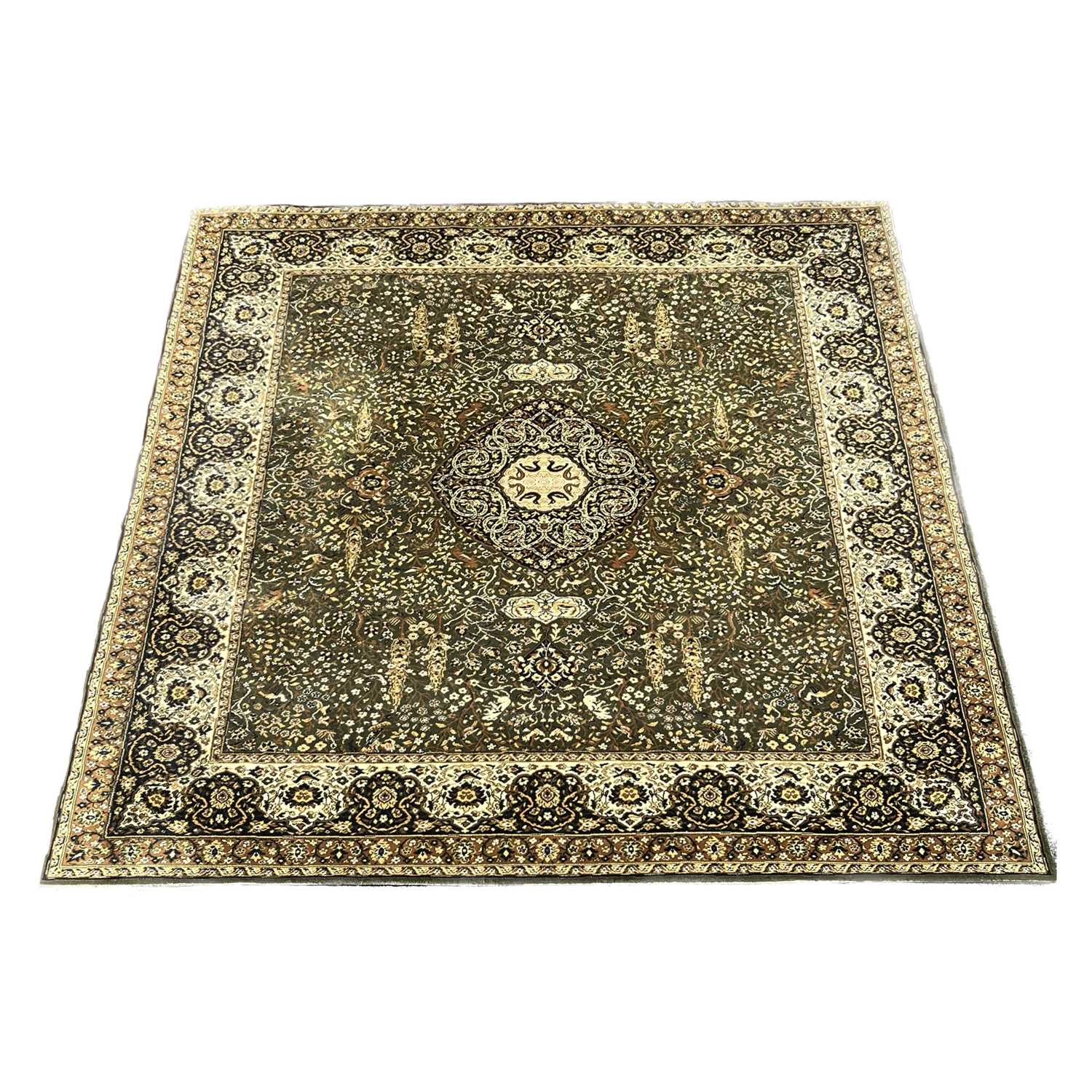 A large rug, muted green field with cream medallion and border designs, covered with floral and