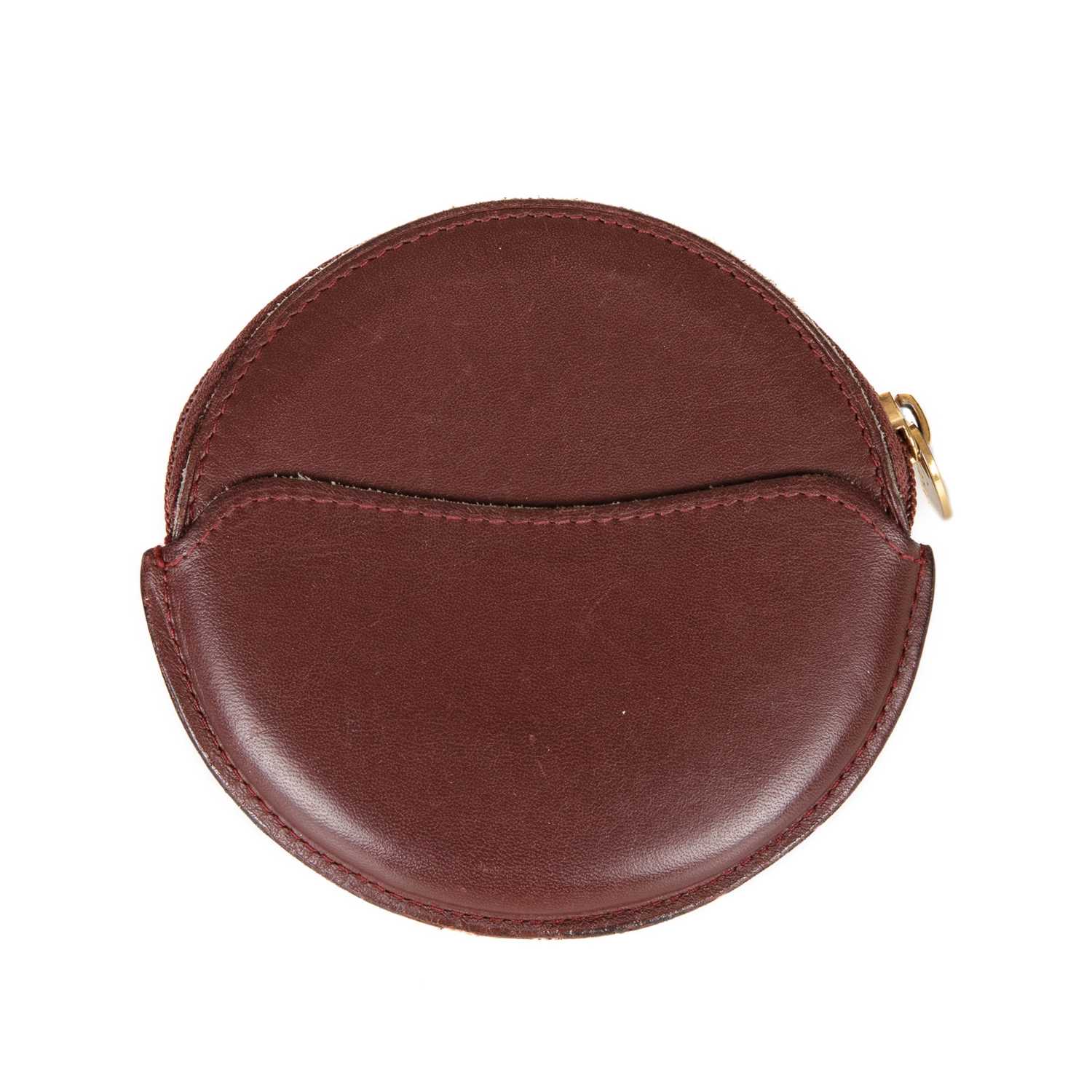 Cartier, a circular Bordeaux coin purse, crafted from smooth burgundy leather, featuring the maker's - Image 2 of 2