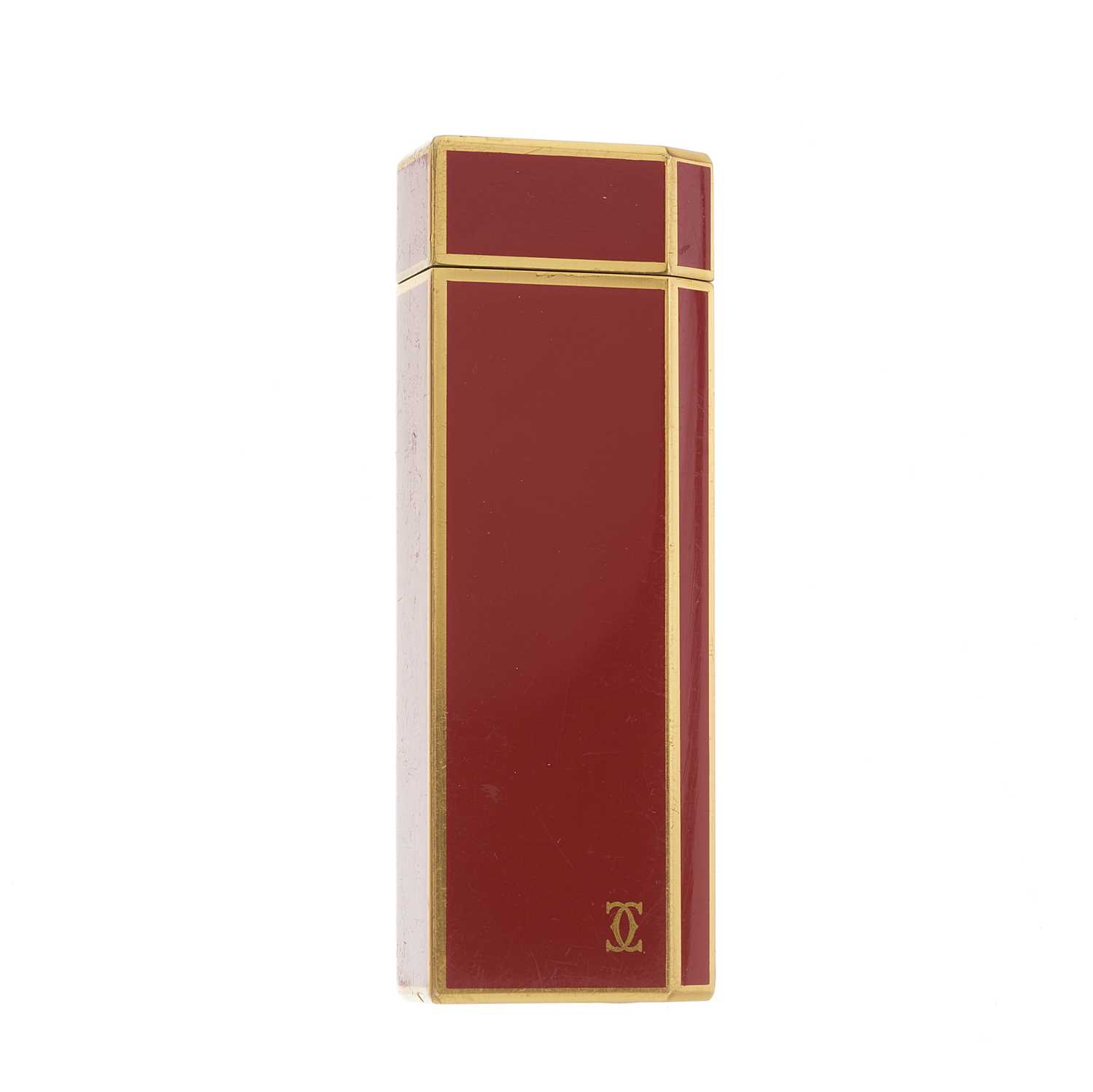 Cartier, an enamel lighter, designed with a gold-plated metal and burnt orange enamel casing, weight