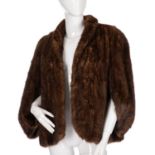 A ranch mink cape shrug, featuring a short lapel collar, cape sleeves, an open front, and an inner