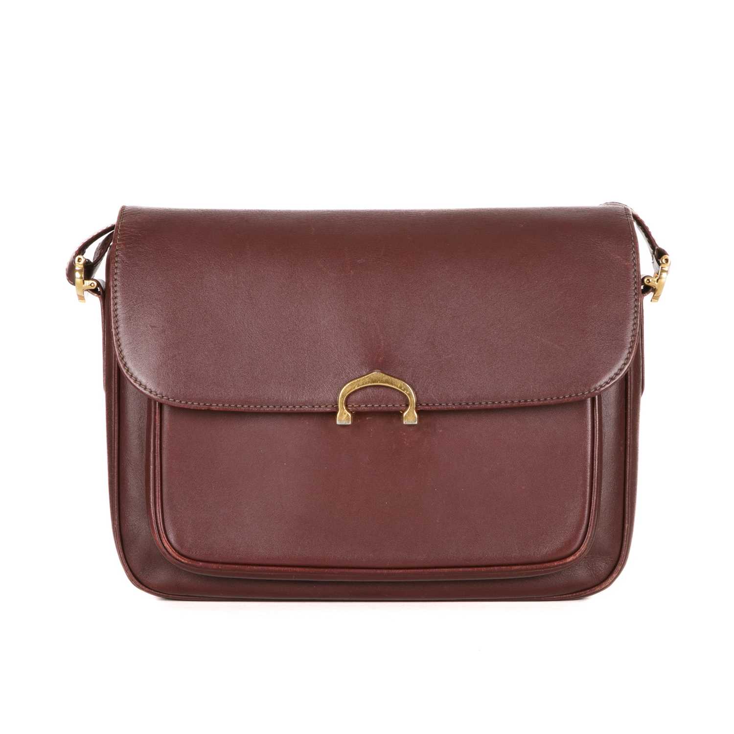 Cartier, a Bordeaux leather handbag, designed with a burgundy leather exterior, featuring gold-