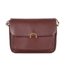 Cartier, a Bordeaux leather handbag, designed with a burgundy leather exterior, featuring gold-