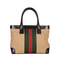 Gucci, a Web tote, designed with a beige canvas exterior with the maker's signature central web