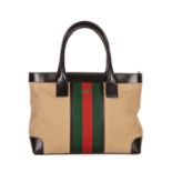 Gucci, a Web tote, designed with a beige canvas exterior with the maker's signature central web