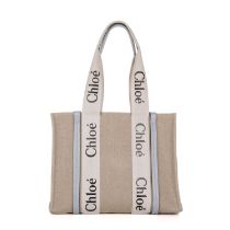 Chloe, a Medium Woody tote, designed with a grey canvas exterior and light blue leather trim,